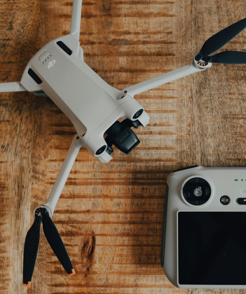 Our Amazon Travel Essentials Top view of a drone and controller set on a rustic wooden surface, showcasing modern technology.